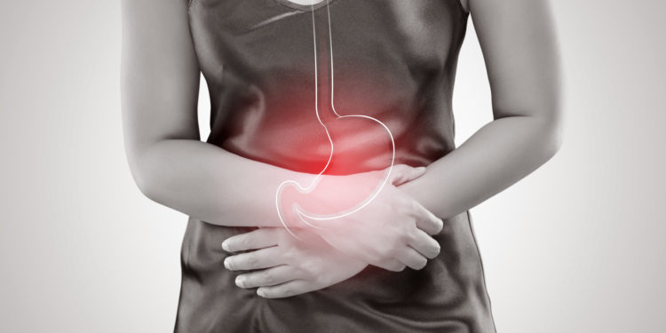 Midsection Of Woman With Hands On Stomach Standing Against Gray Background, Gastritis, Female Anatomy Concept