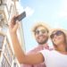 Happy girl making selfie with her boyfriend near by