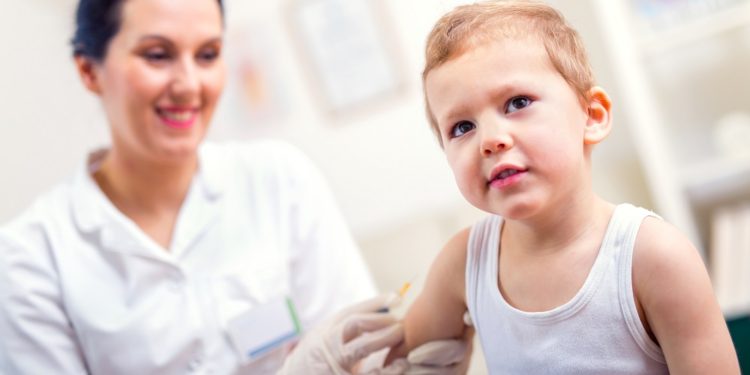 Female pediatrician makes vaccination to small boy