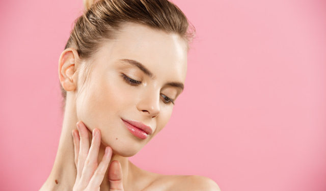 Beauty skin Concept - Beautiful Young Caucasian Woman with Clean Fresh Skin look away with pink studio background. Girl beauty face care. Facial treatment. Cosmetology , beauty and spa.