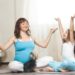 Family healthy lifestyle concept. Pregnancy Yoga and Fitness. Young pregnant mom meditating with dog and happy kid girl in living room. Child feeling joyful on meditation session with mother at home