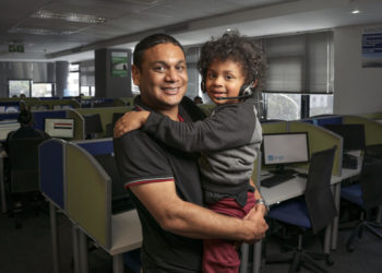 Fahiem Abrahams, 37, holds his son Fawad, 4, for a portrait taken at the Wonga call centre where Fahiem works in Cape Town, South Africa on 7 May 2019. Fawad, who lives with autism, communicates primarily through musical intonation rather than words. “For someone who’s non-verbal, he’s very vocal,” Fahiem says. “A year and a half ago he was basically mute. Now anything he says is music to my ears. He sings all the time, but I can’t make out what he’s saying.” In January 2019, Fawad began attending Alpha School for Learners with Autism. In the months since then, he has made tremendous strides forward, passing developmental milestones that his parents worried he might never reach. While Fawad’s enrollment at Alpha School has been a life-changing event, it has also created new challenges for the family. The school is located far from Fahiem’s office and his family's home, requiring a two-hour commute each morning. But Fahiem says that “just being there for your kids” is the most important part of being a dad.

Fawad, age 4, wanders into the room, his thick mop of long, loose curls swaying with each small footfall, with a melodic string of sounds tumbling from his smiling lips. “For someone who’s non-verbal, he’s very vocal,” says Fawad’s father, Fahiem Abrahams, 37. “A year and a half ago he was basically mute. Now... he sings all the time, but I can’t make out what he’s saying.” Fawad, who lives with autism, is the middle of three children. His family lives in Bonteheuwel, Western Cape, South Africa. “If you go to an autism workshop, you’ll see three fathers and 40 mothers,” Fahiem says. “I don’t know why fathers are so disengaged.”

Taheera, Fahiem's wife, interjects: “Fathers struggle to accept (autism), where mothers have no choice but to accept. It’s a maternal value to accept, where fathers don’t want to give up their dreams.”

Fahiem nods his head in agreement.At first, Faheim and Taheera felt helpl