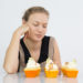Concentrated young woman thinking of missing ingredient in cupcakes while testing them. Displeased housewife preparing dessert for Halloween. Confectioner concept