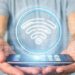 View of Businessman holding Wifi icon with stats and binary code 3d rendering