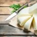 Soft cheese with a branch of mint. On a wooden background.