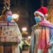 Young family having fun while walking and shopping Christmas gifts in the city. They wears a protective mask to protect from corona virus COVID-19.