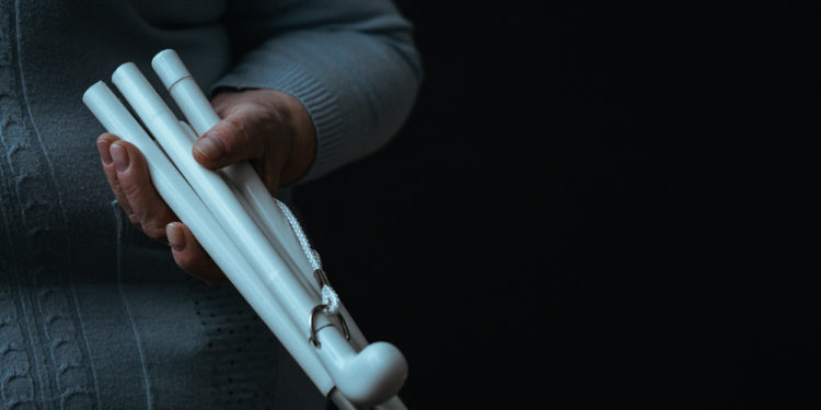 Lonely older blind person's white walking stick