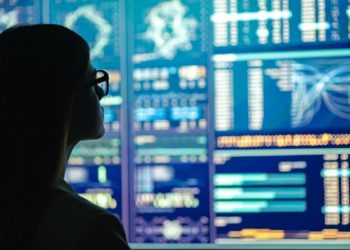The businesswoman in glasses standing near the display