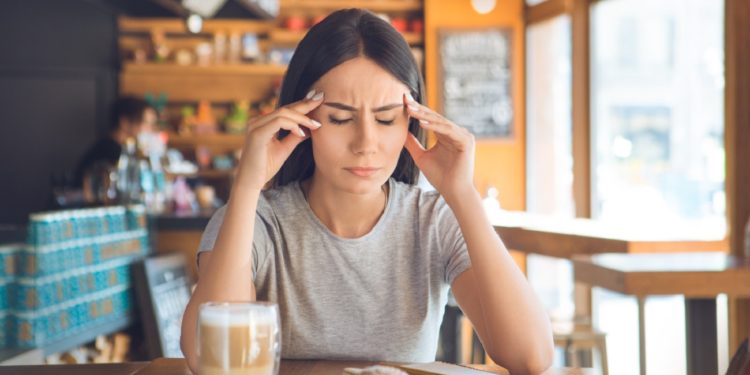 Young female sitting in a cafe indoors rest sick