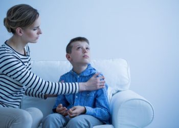 Mother and her autistic son sitting on the sofa