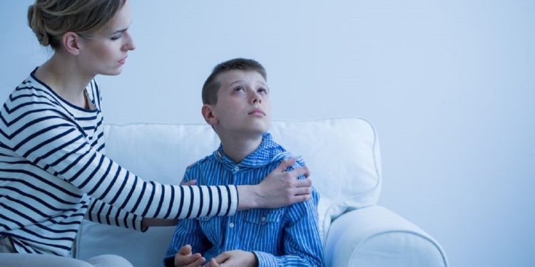 Mother and her autistic son sitting on the sofa