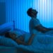 The man sit on the bed with an insomnia near woman. night time