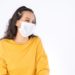 Young happy Asian woman wearing hygienic mask to prevent infection corona virus Air pollution pm2.5 she wearing a yellow sweater shoot in shot isolated on white background