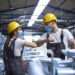 Factory workers greeting each others with elbows during corona virus pandemic.