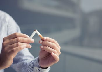 Man breaking cigarette in half. Stop smoking concept.
