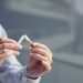 Man breaking cigarette in half. Stop smoking concept.