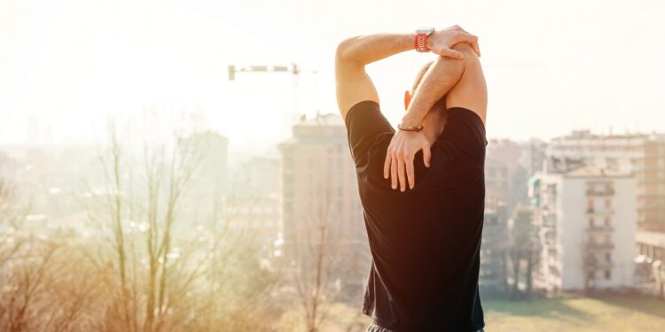 Young man stretching outdoor looking scenic view - Male sportsman workout in the city looking future - sport, excercise, achievement concept