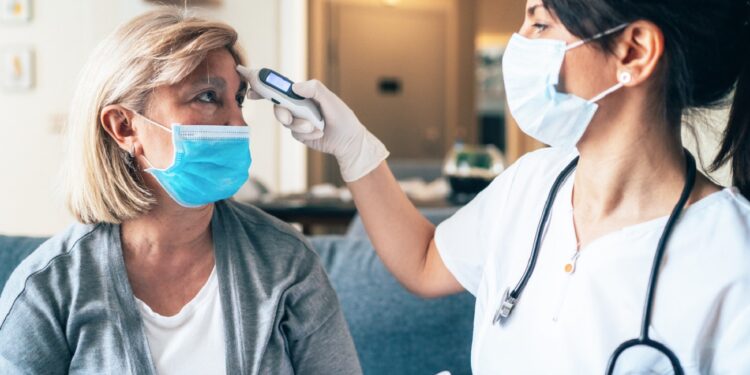 Female doctor doing medical exam to a senior woman at her home