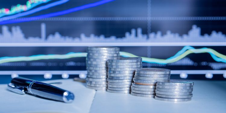 Stack of money coin with trading graph. financial investment concept use for background.