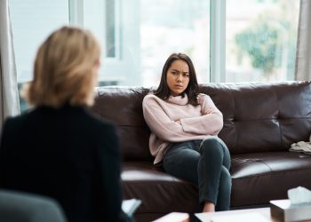 Shot of a young woman having a therapeutic session with a psychologist