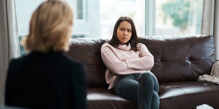 Shot of a young woman having a therapeutic session with a psychologist