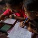 July 24, 2020 - Phnom Penh (Cambodia). Nha Nha helps her smaller sister Sopheap with her home-works using a live streaming lesson. The school has been using streaming apps to provide essential teacher-student interaction and creating a series of physical training exercises. Using Google classroom, Telegram and Facebook Groups, as well as Messenger, allow students to continue studying from the safety of home. To ensure students have suitable equipment to learn online, ISF loans tablet computers to those in need. Subsidies are also available for students who struggle to afford internet service. © Thomas Cristofoletti / UNICEF