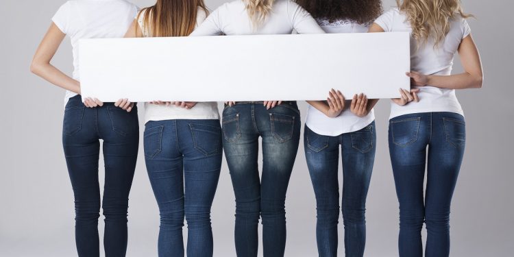 Girls in jeans holding empty banner