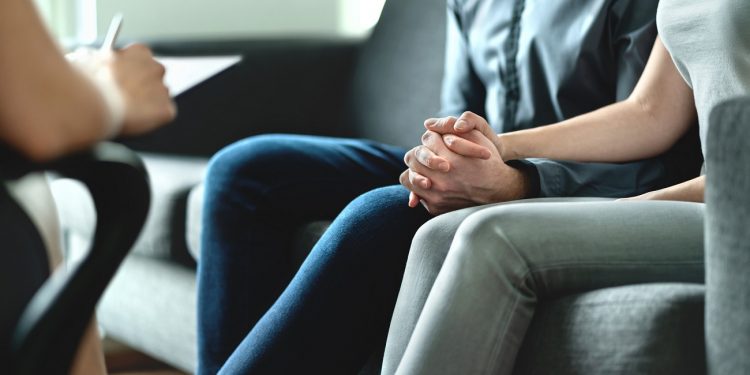 Counseling and therapy for couple and family. Adoption, psychology or psychotherapy concept. Session with psychiatrist or psychologist. Husband and wife with marriage counselor. Man, woman and doctor.