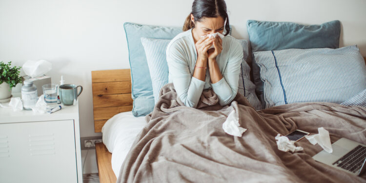 Woman with flu in bed, she use home medicine to handle sickness