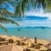 Beautiful tropical beach sea and ocean with coconut palm tree  and umbrella and chair on blue sky and white cloud for holiday vacation travel