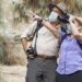 Couple appreciating the beauty of nature with binoculars during the new normal