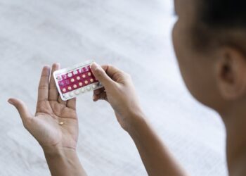 Close-up of young woman's hand holding birth control pills