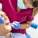 Young Dentist Woman Doing a Check Up to a Patient. Man Going to the Dentist. Man Getting a Checkup at the Dentist Clinic. Healthcare Concept.