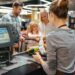 Beautiful family standing at the cash counter buying groceries at the supermarket
