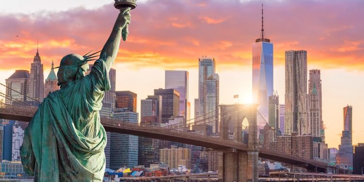 Statue Liberty and New York city skyline at sunset, in United States