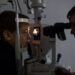 Optician testing a boy's eyes with optometry devices