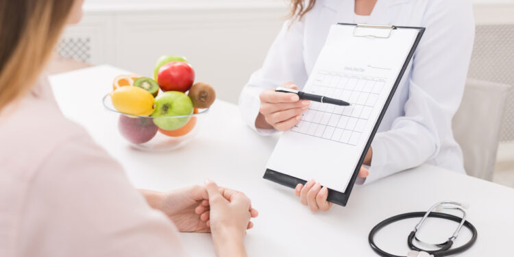 Food coaching. Professional dietitian explaining meal plan to patient at consultation