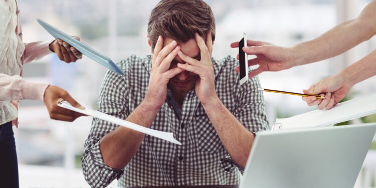 Stressed man frustrated with electronic devices in office