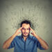 Closeup sad young man with worried stressed face expression and brain melting into lines question marks. Obsessive compulsive, adhd, anxiety disorders