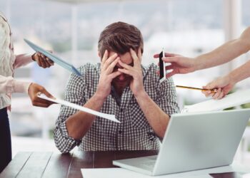 Stressed man frustrated with electronic devices in office