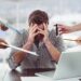 Stressed man frustrated with electronic devices in office
