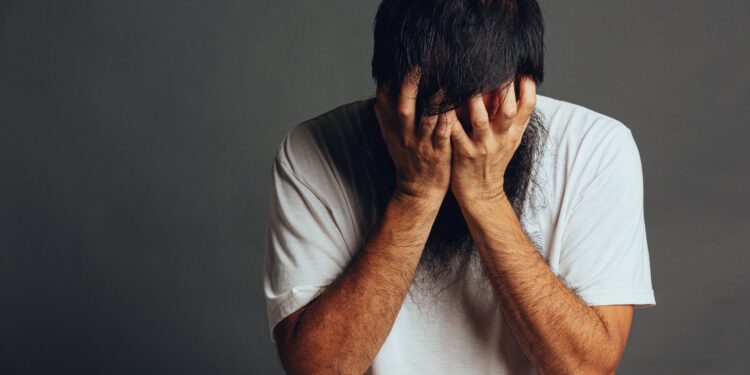man stress out and cover his face by his hands