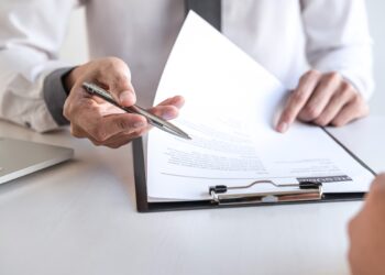 Employer or recruiter holding reading a resume during about colloquy his profile of candidate, employer in suit is conducting a job interview, manager resource employment and recruitment concept.