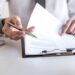 Employer or recruiter holding reading a resume during about colloquy his profile of candidate, employer in suit is conducting a job interview, manager resource employment and recruitment concept.