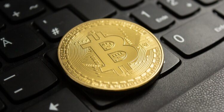 A closeup shot of a bitcoin put on a black computer keyboard