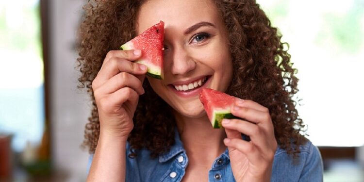 Young woman with a slice of watermelon