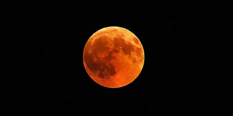 A beautiful shot of a red moon, total lunar eclipse with a black night sky in the background
