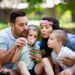 Happy family with children blow soap bubbles outdoor