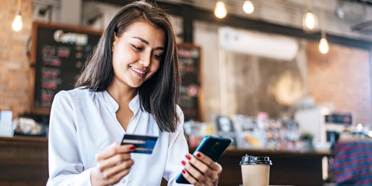 Pay for goods by credit card through a smartphone in a coffee shop.