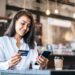 Pay for goods by credit card through a smartphone in a coffee shop.